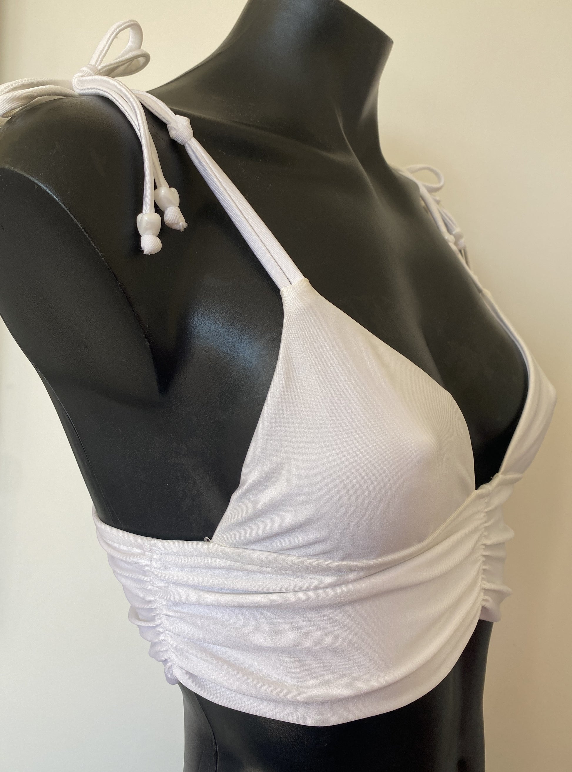 Close-up of MissManeater reef knot shoulder straps on white bralette bikini top