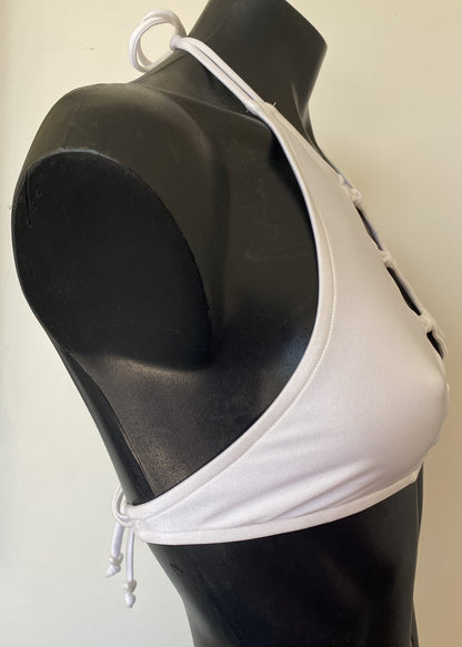 Side profile of the Miss Maneater white designer bikini crop top showing sculpted halter neckline and smooth nylon lycra finish.